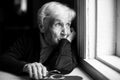 An elderly woman sadly looking out the window Royalty Free Stock Photo