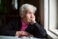 An elderly woman sadly looking out the window. Royalty Free Stock Photo