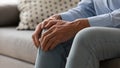 Elderly woman feeling pain touches knee close up image