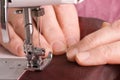 Elderly woman sews on the sewing machine