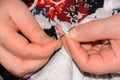 An elderly woman sews things up using threads and a needle. Clothes torn and a hole formed. Clothing repair