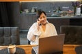 elderly woman in shirt looks at laptop screen smiling at modern kitchen. Royalty Free Stock Photo