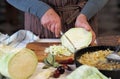 An elderly woman shreds cabbage to prepare dinner.Home cooking Royalty Free Stock Photo