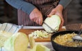 An elderly woman shreds cabbage to prepare dinner.Home cooking Royalty Free Stock Photo