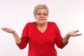 Elderly woman shrugging shoulders and throwing up her hands, emotions in old age