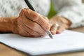 Elderly woman signing document, focus on hand with pen Royalty Free Stock Photo