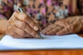 Elderly woman signing document, focus on hand with pen Royalty Free Stock Photo