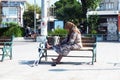 Elderly woman sits alone on bench