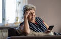 Elderly woman using mobile phone at home Royalty Free Stock Photo