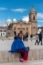 Elderly woman sitting on the edge of the main square of the city of Tunja. Colombia.