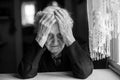 An elderly woman sitting at the table in a depressed state Royalty Free Stock Photo