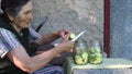 Elderly woman slice squash and put into jar