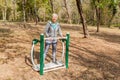 Elderly Woman In Sports Clothes Exercising At Outdoor Fitness Park