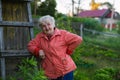 An elderly happy woman stands near her house in the village. Royalty Free Stock Photo