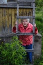 Elderly woman stands near her village house. Royalty Free Stock Photo