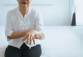 Elderly woman suffering with parkinson`s disease symptoms on hand