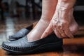 Elderly woman swollen feet putting on shoes Royalty Free Stock Photo