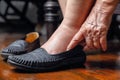 Elderly woman swollen feet putting on shoes Royalty Free Stock Photo