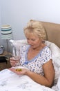 Elderly woman taking tablets at bedtime Royalty Free Stock Photo