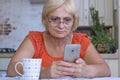 Elderly woman texts on mobile phone