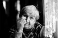 An elderly woman threatens with a finger looking at the camera. Black and white photography.