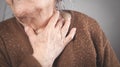 Elderly woman touching the neck feeling sore throat pain