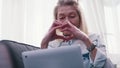 Elderly woman using laptop for a video call. Sending heart to her family