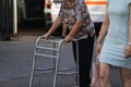 Elderly woman using a metal walker