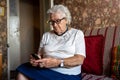 Elderly woman using mobile phone at home Royalty Free Stock Photo