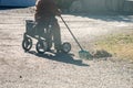 Elderly woman with walker, rakes the lawn and doing gardening work Royalty Free Stock Photo