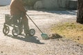 Elderly woman with walker, rakes the lawn and doing gardening work Royalty Free Stock Photo