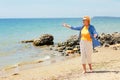 Elderly woman walking on the beach near the sea Royalty Free Stock Photo