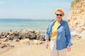 Elderly woman walking on the beach near the sea Royalty Free Stock Photo