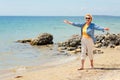 Elderly woman walking on the beach near the sea Royalty Free Stock Photo