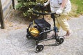 Elderly woman walking outside with rollator or wheeled walker