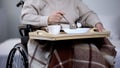 Elderly woman wheelchair eating dinner in nursing home, hospital service, food