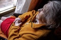 Elderly woman in a wheelchair looking out the window