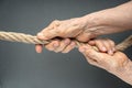 Elderly woman wrinkled hands pull the rope