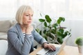 Elderly woman writer in white working on new article