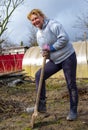 An elderly woman 65 years old is digging in the garden in early spring Royalty Free Stock Photo