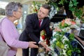 Elderly woman buying flowers at funeral service