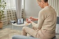 An elderly woman communicates remotely via a tablet with her doctor and takes medications according to his recommendations. Royalty Free Stock Photo