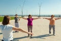 Elderly women doing sports training with a trainer in a public park, recreation fitness after sickness. Royalty Free Stock Photo