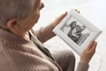 Elderly woman with framed family portrait Royalty Free Stock Photo