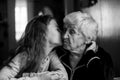 Elderly woman grandmother kiss with her little granddaughter.