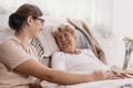 Elderly woman in hospital bed with social worker helping her Royalty Free Stock Photo