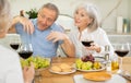 Elderly women and man talking and drinking wine Royalty Free Stock Photo