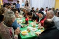 Elderly women and men have a food at the Christmas charity dinner for the homeless