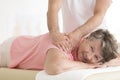 Masseur setting elderly woman shoulder