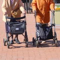 Two elderly women street rollator walking outdoor